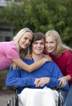 Group picture of teenage girl and young woman with their friend sitting in wheelchair