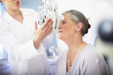 Eye doctor examining senior woman's vision