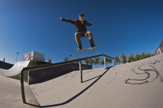 Germany, North Rhine-Westphalia, Duisburg, Skateboarder performing trick on ramp at skateboard park