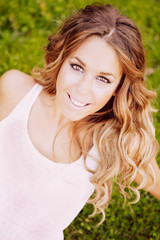 Naklejka premium Cool pretty woman with a beautiful smile on the grass
