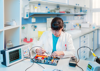 Young scientist repairs electronic device