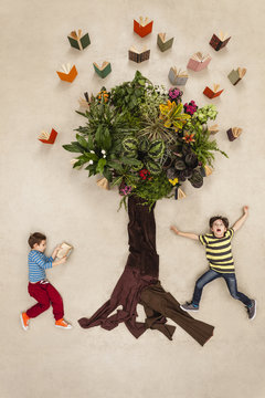 Children watching books flying out of tree
