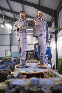 Two smiling diesel mechanics in factory