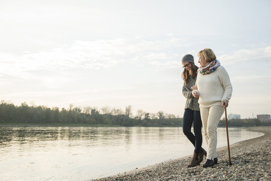 Young woman assisting her grandmother walking