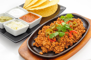 Fried minced beef on hot plate with sauce and crispy flapjacks