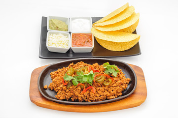 Fried minced beef on hot plate with sauce and crispy flapjacks