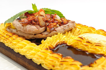 Meat steak surrounded with cake of mashed potatoes, studio shot