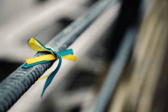 Blue-yellow bow on metal fence - colors of flag of Ukraine