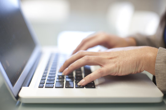 Hands of young woman using laptop