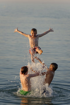 Italy, three teenage boys having fun at seaside