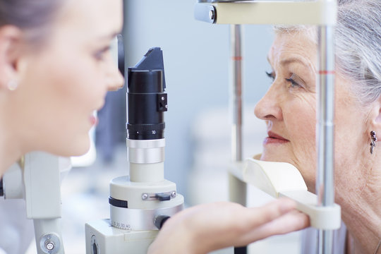 Eye doctor examining senior woman's vision