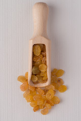 Wooden scoop with golden raisins