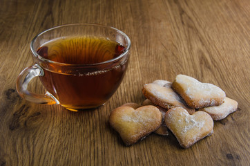 Glass cup tea with heart shaped cookies