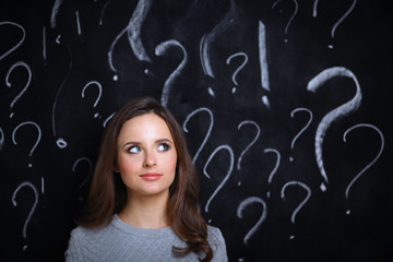 Young girl with question mark on a gray background