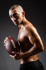 Foto op Canvas Muscular football player with ball © Elnur