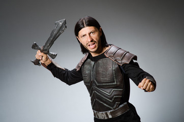Fototapeta premium Angry knight with sword against dark background