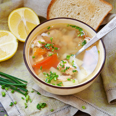 Rustic fish soup in a bowl on a wooden background