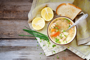Rustic fish soup in a bowl on a wooden background