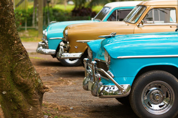 Front of three classic old car in Cuba