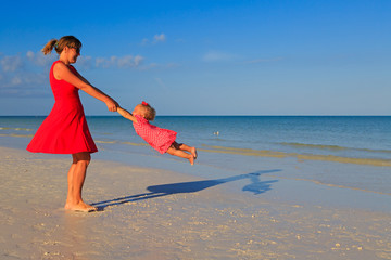 mother and daugher playing on summer beach