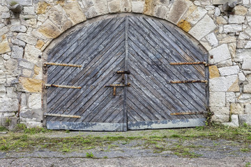 Fototapeta na wymiar Old stone wall and wooden gate