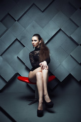 Naklejka premium fashionable model sitting in a red chair