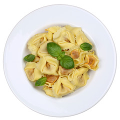 Italienische Nudeln Tortellini mit Basilikum auf Teller Freistel