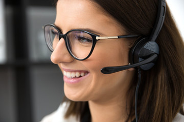 Closeup portrait of a smiling female support operator in headset