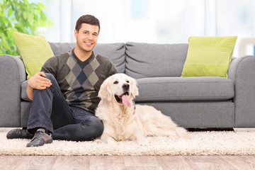 Young man sitting on the floor with his dog