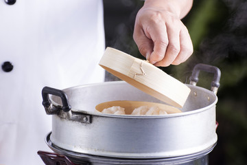 Chef cooking dumpling with streamed pot