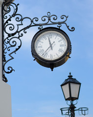 Fototapeta na wymiar The town clock and street lamp