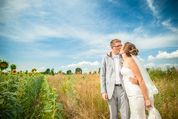 bride and groom on sunflower field
