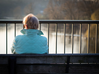 seniorin sitzt allein auf einer parkbank