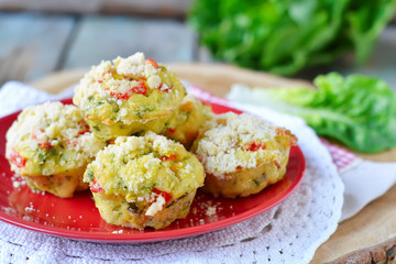 zucchini muffins with red pepper on a wooden background