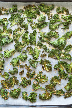 Curly Kale Chips Sprinkled with Parmesan Cheese and Flax Seeds