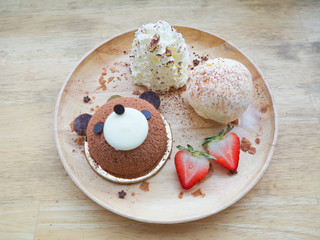 Teddy bear chocolate cake with whipped cream in a wooden dish