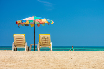 Beach umbrellas and sunbathe seats on Phuket sand beach in South
