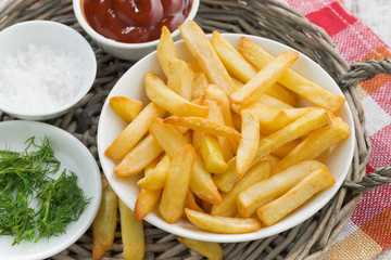 fried french fries with tomato sauce and herbs, top view
