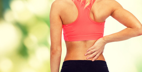 close up of sporty woman touching her back
