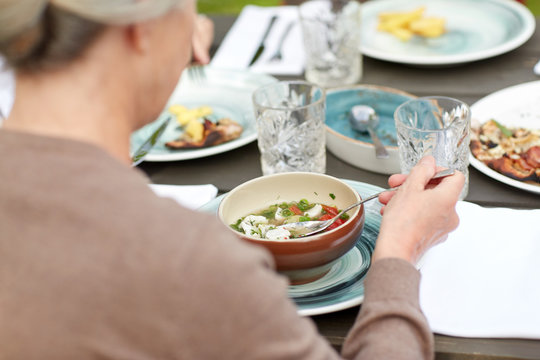 Close Up Of Woman Eating Soup In Summer Garden