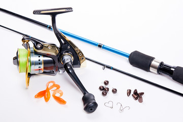 Fishing rod and reel with silicone baits on white.