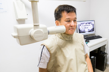Man with radiation protection vest receiving dental  X-Ray