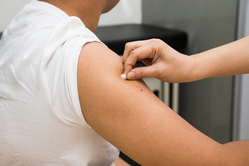 Doctor swap arm of patient with alcohol before vaccination