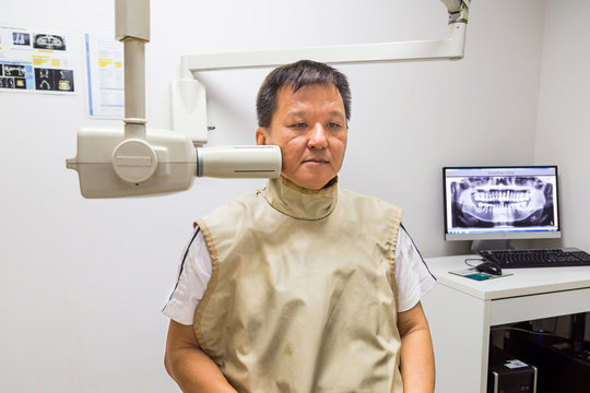 Man with radiation protection vest receiving dental  X-Ray