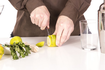 Bartender preparing mojito cocktail drink, with limes, ice and b