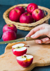 cut with a knife fresh red apples on a wooden board, fruits