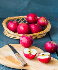 cut with a knife fresh red apples on a wooden board, fruits