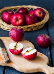 cut in half fresh red apples on a wooden board, fruits