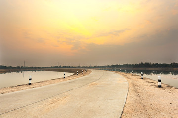 Concrete road and lake landscape in the morning