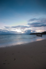 Boat on the beach at sunrise in tide time.